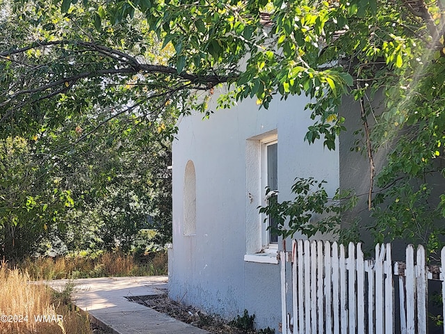 view of home's exterior featuring fence and stucco siding