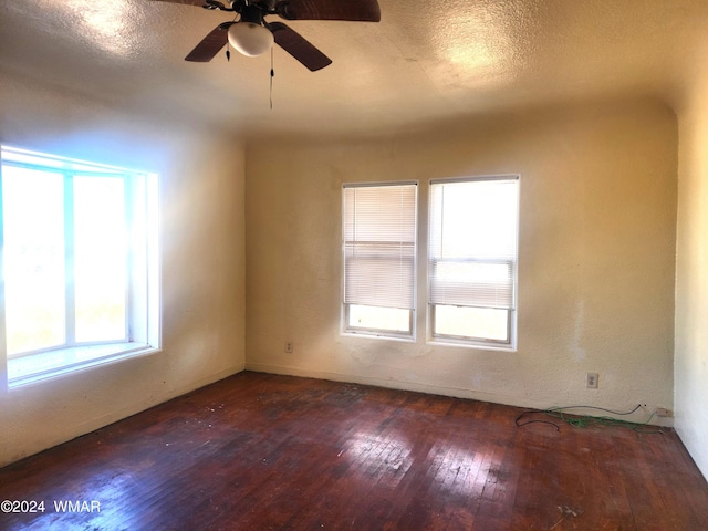 spare room featuring dark wood-style floors, a textured ceiling, and a ceiling fan