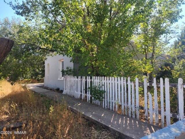 view of side of home with fence and stucco siding