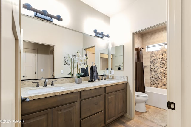 bathroom with a sink, toilet, and double vanity