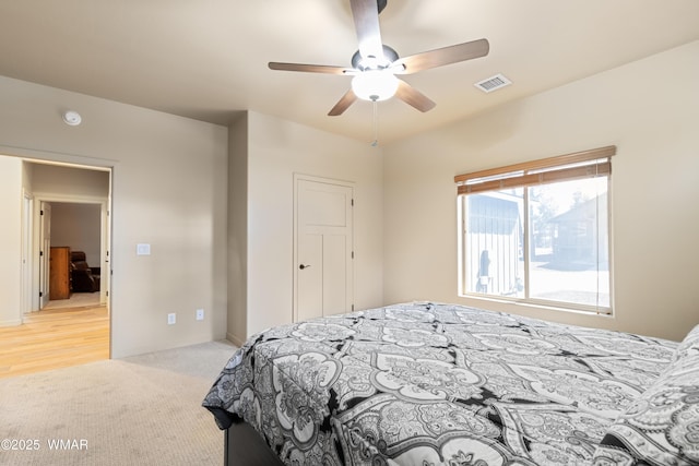 bedroom featuring light carpet, ceiling fan, and visible vents