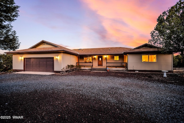 single story home featuring driveway, covered porch, and an attached garage