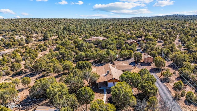 birds eye view of property featuring a forest view