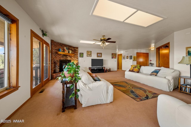 carpeted living area featuring visible vents, a fireplace, and ceiling fan