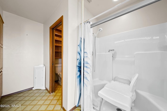 full bathroom with baseboards, toilet, and tile patterned floors