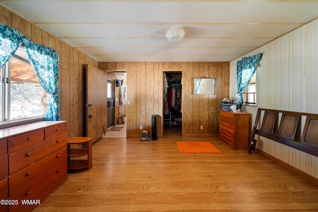 bedroom featuring a closet, a spacious closet, and light wood finished floors