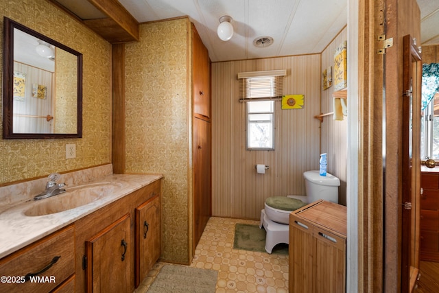 bathroom with visible vents, wallpapered walls, toilet, vanity, and tile patterned floors