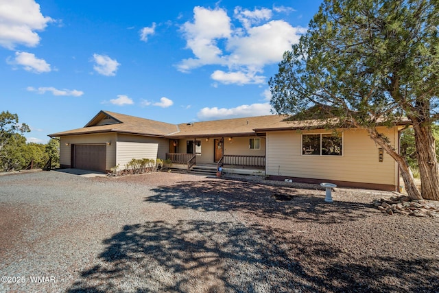 ranch-style home with covered porch, driveway, and a garage