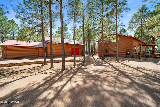 2722 Covered Wagon Trl, Overgaard, AZ 85933 - back of house featuring a metal roof, driveway, and an outdoor structure