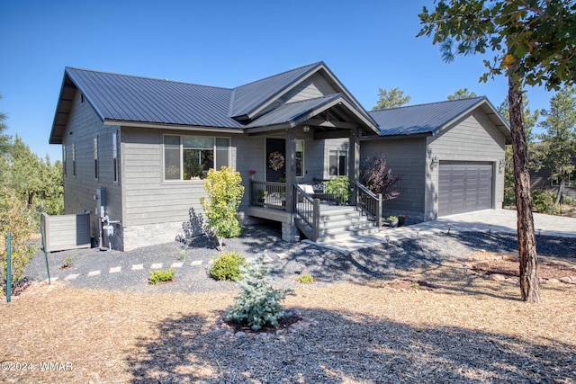 view of front of property featuring metal roof, driveway, and an attached garage