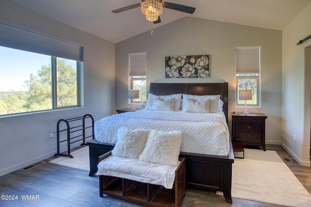 bedroom with dark wood-type flooring, multiple windows, vaulted ceiling, and baseboards