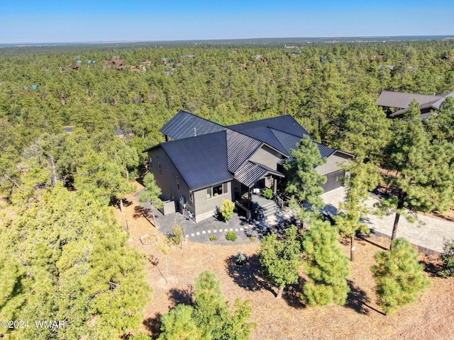 birds eye view of property featuring a forest view