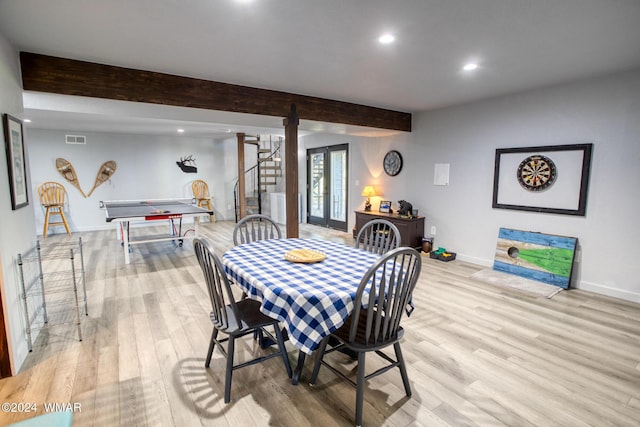 dining space featuring visible vents, baseboards, light wood-style floors, stairway, and beam ceiling