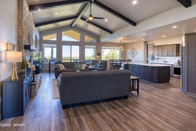 living area featuring a fireplace, high vaulted ceiling, dark wood finished floors, and beam ceiling