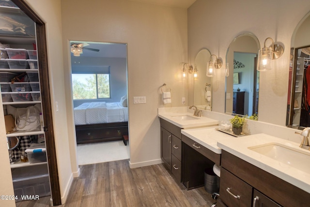 ensuite bathroom featuring double vanity, wood finished floors, a sink, and ensuite bathroom