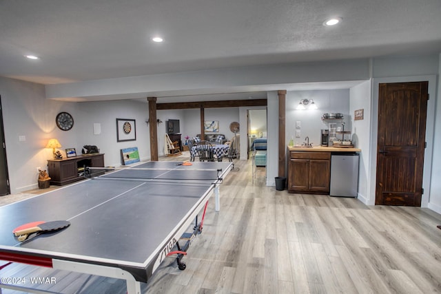 playroom with baseboards, light wood-style flooring, bar area, a sink, and recessed lighting