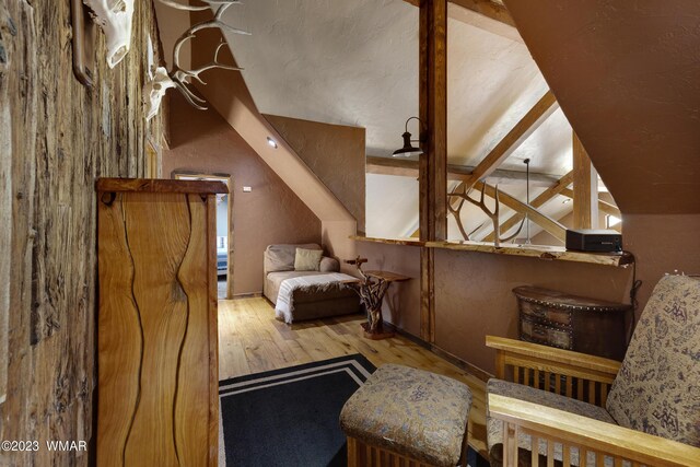 living area featuring lofted ceiling and light wood-style floors