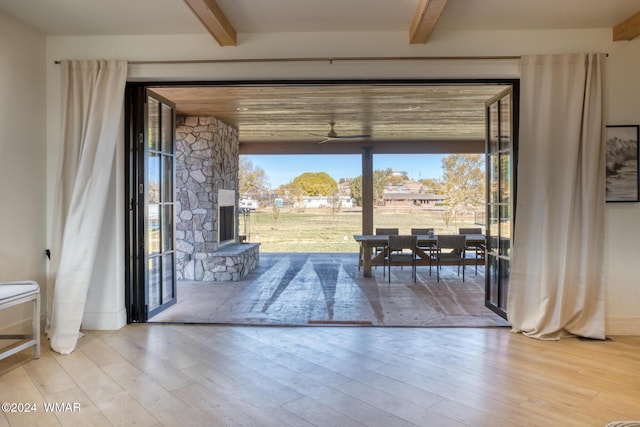 doorway with beamed ceiling and wood finished floors