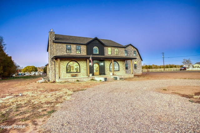 view of front of house featuring covered porch and a chimney