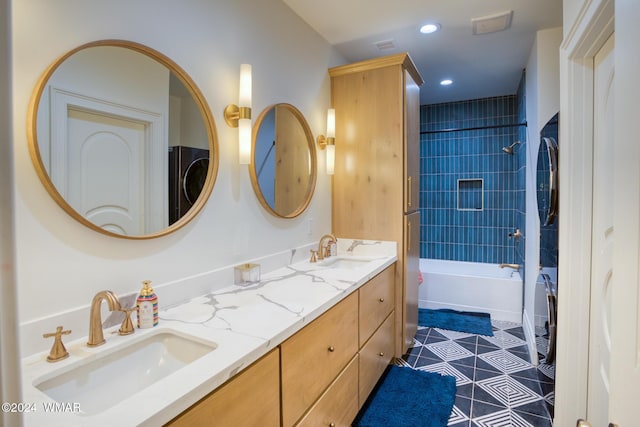 full bathroom featuring  shower combination, a sink, stacked washing maching and dryer, and double vanity