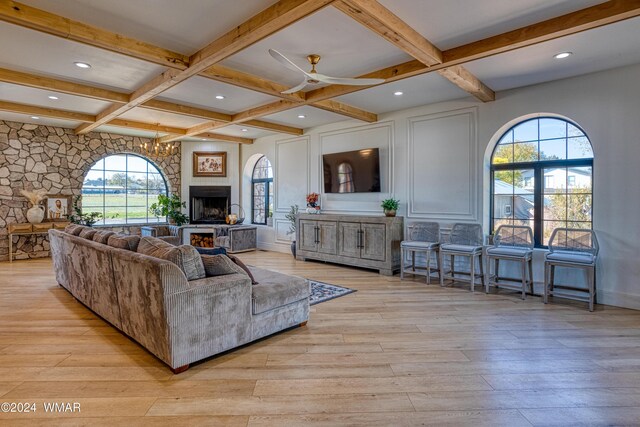 living area featuring light wood finished floors, a fireplace, coffered ceiling, and beam ceiling