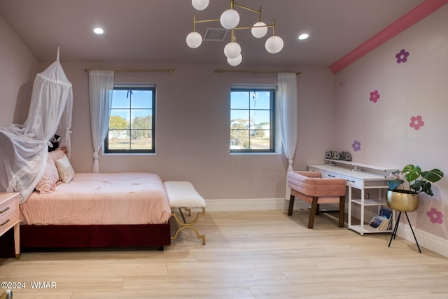 bedroom featuring baseboards, visible vents, light wood finished floors, and multiple windows