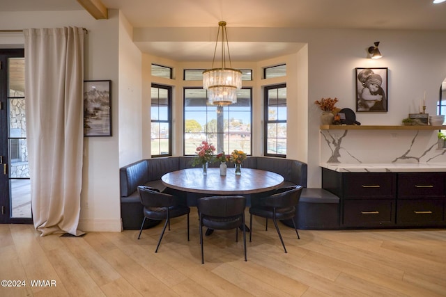 dining room featuring baseboards, light wood-style flooring, and an inviting chandelier