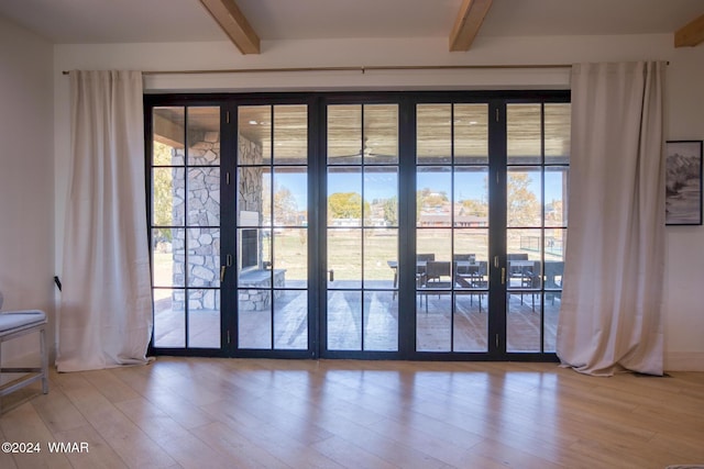 entryway featuring a healthy amount of sunlight, beam ceiling, and wood finished floors