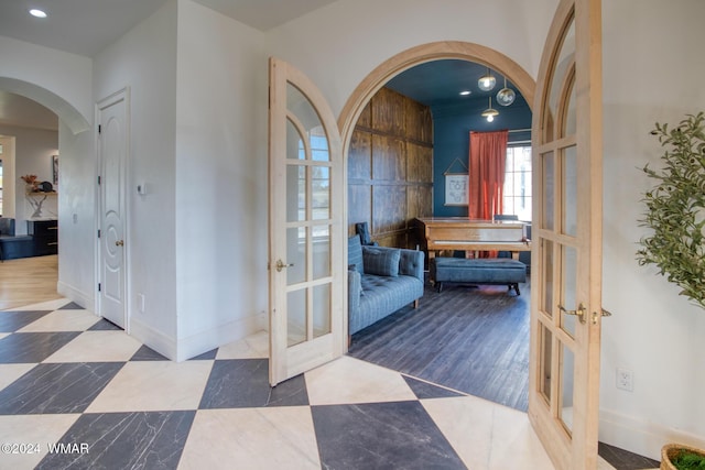 corridor featuring recessed lighting, arched walkways, baseboards, and french doors