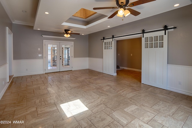 spare room featuring a wainscoted wall, french doors, a barn door, and recessed lighting