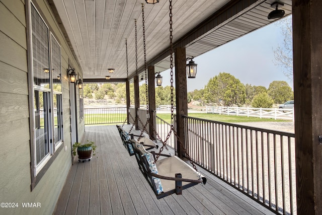 wooden deck featuring fence and a porch