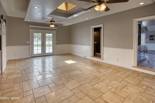 spare room featuring a barn door, wainscoting, ceiling fan, french doors, and recessed lighting