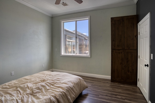 bedroom featuring dark wood-style floors, visible vents, ornamental molding, a ceiling fan, and baseboards