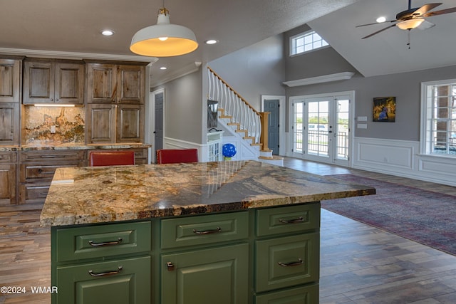 kitchen featuring open floor plan, dark wood-style flooring, a center island, french doors, and green cabinets