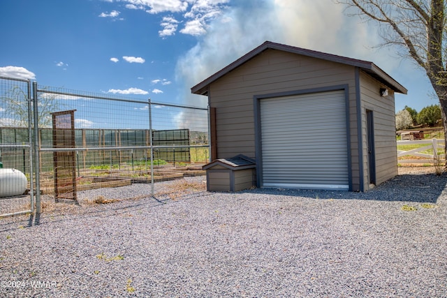 detached garage with driveway and fence