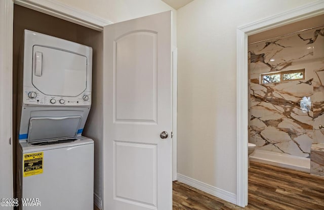 3131 State Route 277, Overgaard, AZ 85933 - laundry room featuring stacked washing machine and dryer, wood finished floors, and baseboards