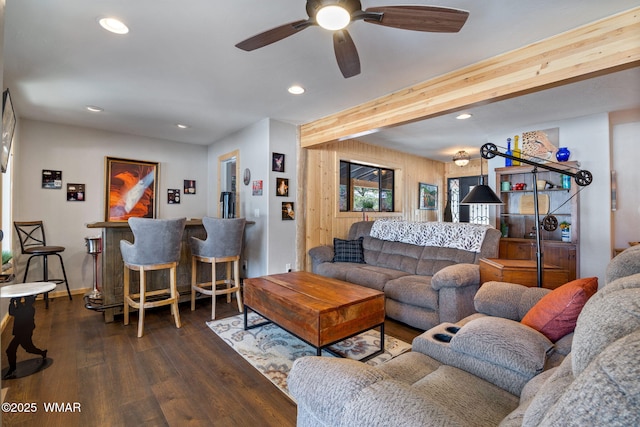 living area with dark wood-style floors, beam ceiling, recessed lighting, and a bar