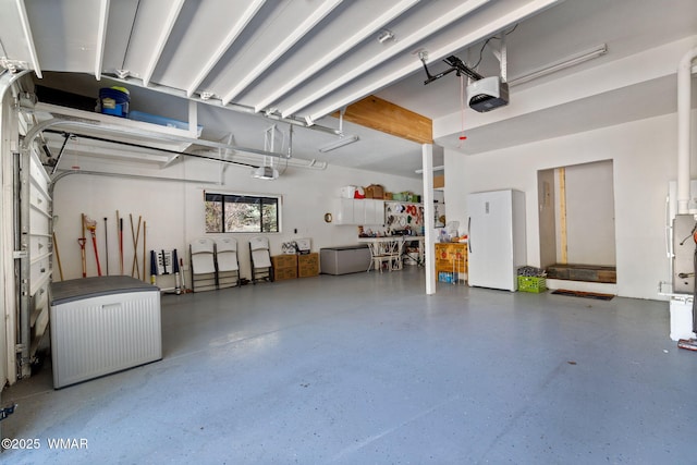 garage featuring a garage door opener and freestanding refrigerator