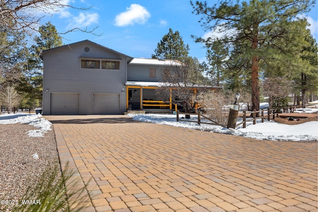 view of front of home with a garage and decorative driveway