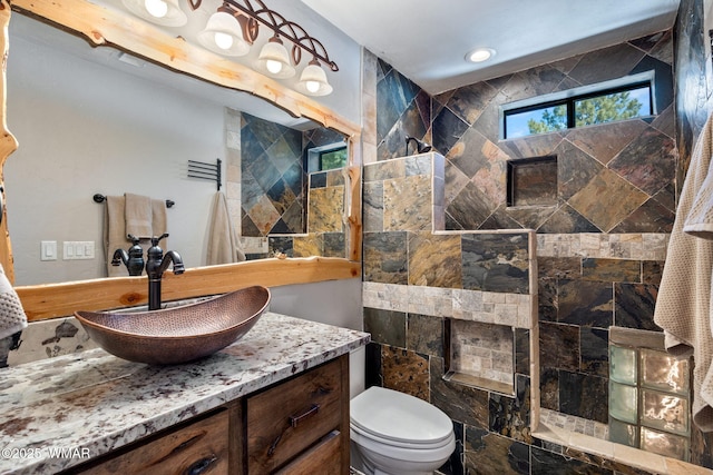 full bathroom featuring vanity, toilet, and a tile shower