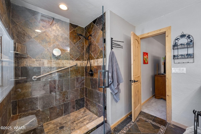 bathroom with recessed lighting, baseboards, and tiled shower