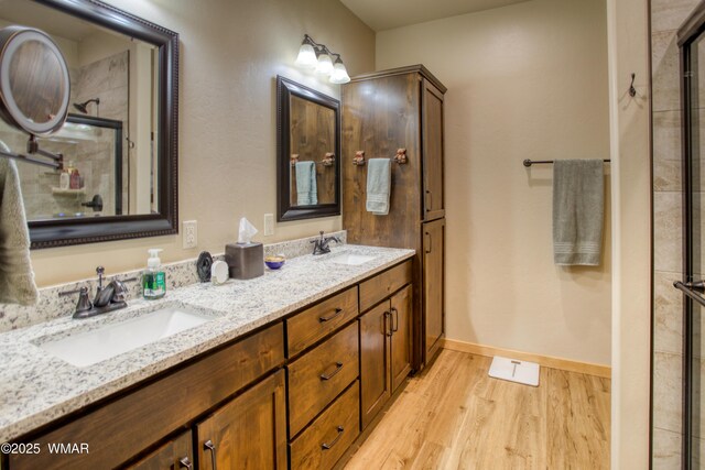 5863 Apollo Way, Lakeside, AZ 85929 - full bathroom featuring wood finished floors, an enclosed shower, double vanity, and baseboards