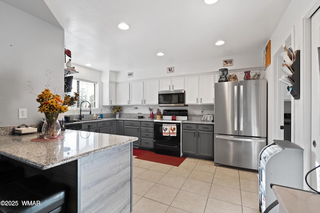 1275 Flag Hollow Rd, Lakeside, AZ 85929 - kitchen featuring stainless steel appliances, gray cabinetry, light tile patterned floors, light stone countertops, and a peninsula