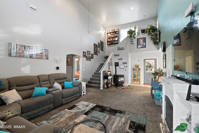 1275 Flag Hollow Rd, Lakeside, AZ 85929 - living room featuring arched walkways, a high ceiling, carpet flooring, stairway, and plenty of natural light