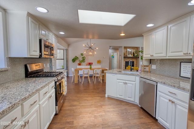 1421 N 36th Dr, Show Low, AZ 85901 - kitchen featuring appliances with stainless steel finishes, white cabinetry, light wood-type flooring, recessed lighting, and tasteful backsplash