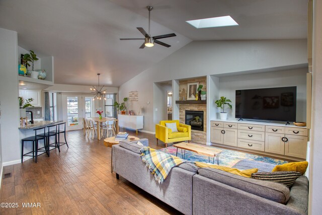 1421 N 36th Dr, Show Low, AZ 85901 - living area featuring a ceiling fan, a fireplace, wood finished floors, baseboards, and a chandelier