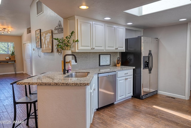 1421 N 36th Dr, Show Low, AZ 85901 - kitchen featuring dishwasher, a sink, fridge with ice dispenser, a skylight, and wood finished floors
