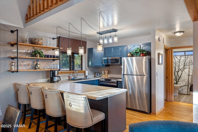 1513 Low Mountain Trl, Heber, AZ 85928 - kitchen with light countertops, a sink, blue cabinets, a peninsula, and stainless steel appliances