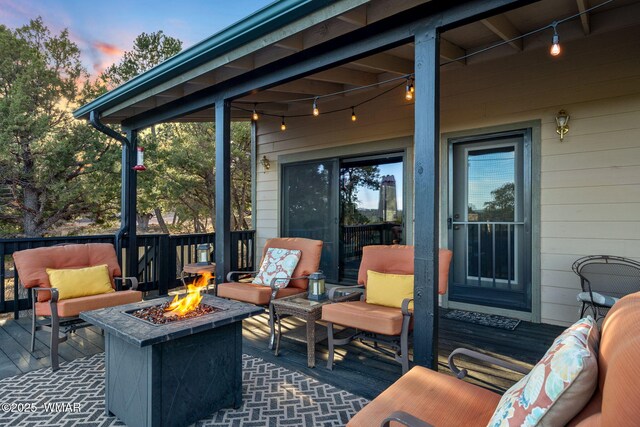 1513 Low Mountain Trl, Heber, AZ 85928 - patio terrace at dusk featuring a wooden deck and an outdoor living space with a fire pit