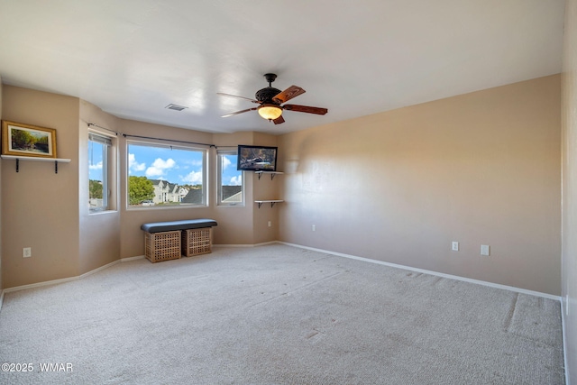 spare room with a ceiling fan, carpet, and baseboards